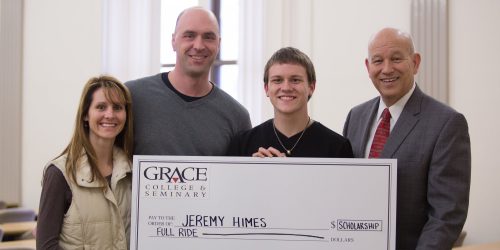 Dr. Katip (far right) presenting Jeremy Himes and his guardians Beth and Brandon McBrier with the Presidential Care Scholarship. 
