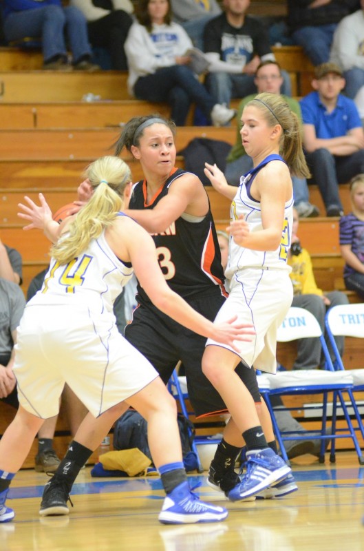 Warsaw's Jennifer Walker-Crawford is defended by a pair of Triton players Wednesday night. Walker-Crawford found the room to score a game-high 18 points to lead undefeated Warsaw to a 49-32 win.
