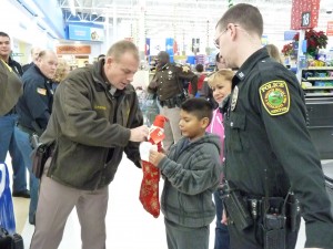 Kosciusko County FOP President Chris McKeand lends a hand to a child during the annual Christmas with a Cop program. (Photo provided)