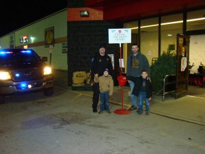 From left to right are  Mentone Police Department Deputy Marshal Terry S. Engstrand, Engstrand’s son Nate and a  citizen Matt Wheeler and his son, Cody, make a donation. (Photo provided)