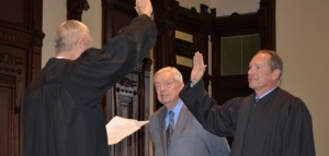 Outgoing circuit court judge Rex Reed, left, swears in newly elected circuit court judge Michael W. Reed while Reed's father, Max Reed, looks on. (Photo by Stacey Page)