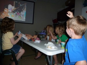 Children enjoy watching a slide-show of their stuffed animals’ nighttime adventures during last summer’s Stuffed Animal Sleepover at the North Webster Public Library.  Pictured from left are Mia Thornsbrough, Amanda Allen, Leona Sandoz and Griffin Sandoz.