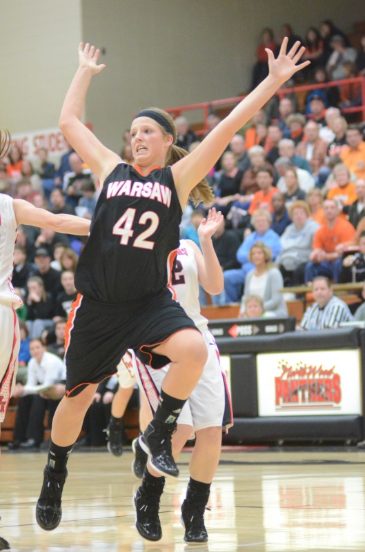 Nikki Grose of Warsaw goes flying after being hit on a drive to the basket Saturday night at NorthWood. The Panthers topped the Tigers 34-30 in NLC play.