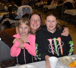 Mary Kester with her daughters, Rose Kester, in pink, and Tristen Barr. The family try to attend a few meals offered by Fellowship Missions throughout the year where they say they enjoy the fellowship and good food.