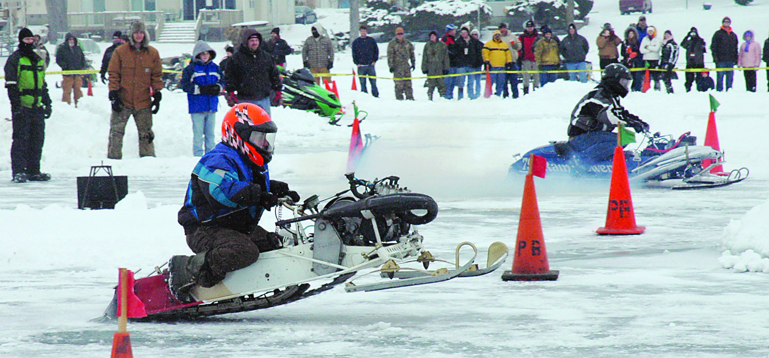 Two snowmobile racers take off during the 2011 Wawasee Kiwanis snowmobile drag races. This year’s snowmobile drags, scheduled for Saturday, Jan. 26, are dependent on ice conditions. Alternative dates have been set, including Feb. 2. (File photo)
