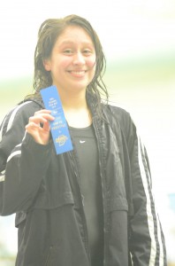 Warsaw junior Cynthia Juarez shows off her blue ribbon Saturday after earning a sectional title in the 500 freestyle.