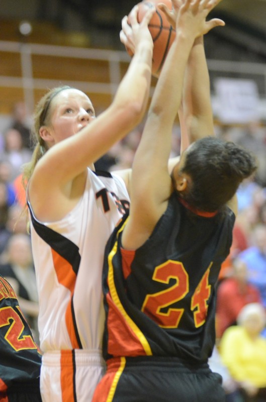 Warsaw's Nikki Grose goes up strong over Alyssa Wagner during sectional play Tuesday night at Concord. The No. 8 Tigers beat Elkhart Memorial 49-37.