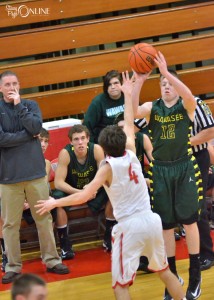 Wawasee's Jeffrey Moore shoots over Goshen's Austin Henke ahead of the watchful eye of Warrior head coach Phil Mishler Thursday night. (Photos by Nick Goralczyk)