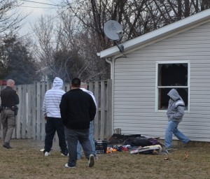 A resident of 1522 Dot St., Warsaw, tries to stomp out burning materials that were thrown from a window.