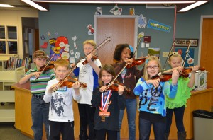 Students at Eisenhower Elementary stand poised with violins during the violin Course at Eisenhower Elementary.  (photo by Alyssa Richardson)