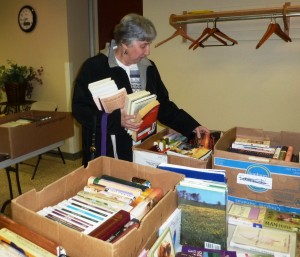 Paula Ibach of Winona Lake finds lots of good buys at the Friends of the Library Book Sale in North Webster last week.  As head of the Grace Village library committee, Paula came to the sale to stock up on books for the library at Grace Village. (Photo provided)