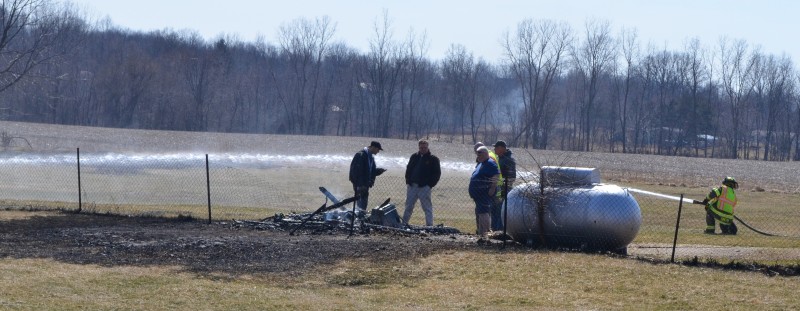 Kosciusko County Sheriff's Department and Squad 70 investigators look over a pile of burned debris that resulted in a grass fire. (Photo by Stacey Page)