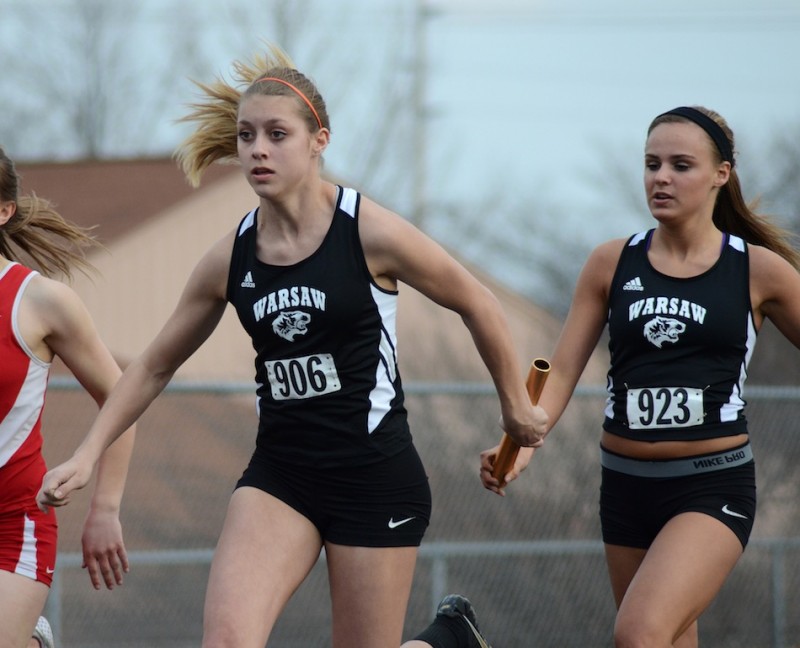 Sam Alexander takes the baton from teammate Mariah Harter during the 4 X 100 relay. The pair helped Warsaw win the event.