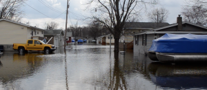 Susie Rhoades, pictured on the steps of her home to the left, wasn't sure what she was going to do on Thursday as water continued to rise on B61H Lane.