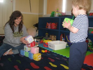 High school intern Tori Lambright helps 18-month-old Zalen Eldridge with block building.  Tori is serving an internship at Teen Parents Succeeding through Wawasee High School's Professional Career Internship Program.