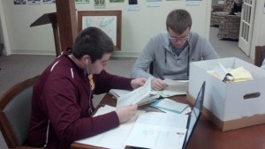 History Majors Caleb Day and Jeff Watkins evaluate documents in the Reneker Museum of Winona History.