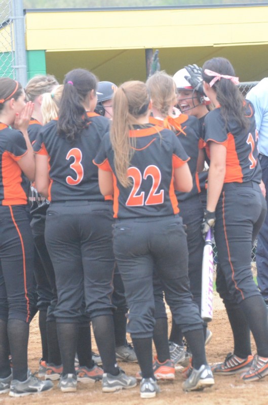 Members of the Warsaw softball team congratulate Ashley Ousley after she belted a home run Friday night.
