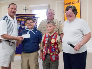 Tracy Furnival, left, president of Warsaw Breakfast Optimist Club, accepts a donation from Scout Wyatt Klinger, Scout Carson Kerlin and Scout Leader Sheri Reeve. In the back is Jim Reeve, Warsaw Breakfast Optimist and Scout Leader. (Photo provided) 