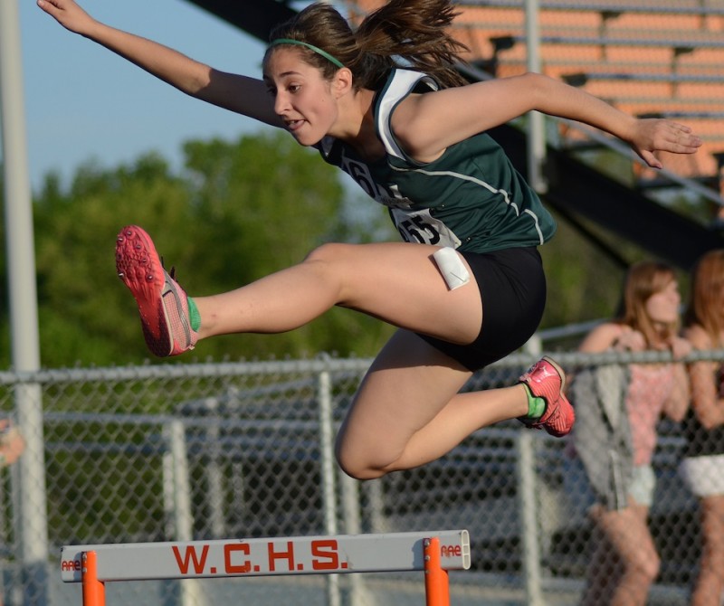 Wawasee freshman Sarah Lancaster soars over a hurdle during sectional action in Warsaw Tuesday night (Photos by Jim Harris)