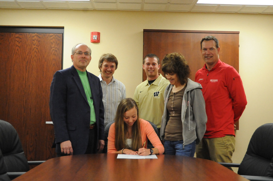 Wawasee High School senior Jen Slabaugh signs the dotted line in committing to Indiana Wesleyan University to continue her track and cross country careers. Slabaugh is joined by parents Brian and Kathy Slabaugh as well as Wawasee cross country and track coach Jerid Stoffel, Wawasee cross country and track coach Doug Slabaugh and Indiana Wesleyan University assistant coach Eric WHAT. (Photo by Mike Deak)