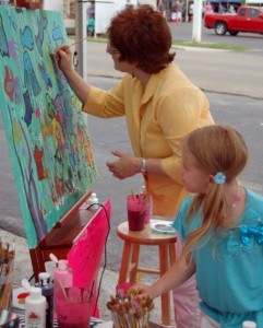Alina Conley, 7, checks the work of fellow artist Cindy Bryan