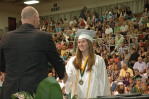 Emma Donahoe, Wawasee High School student, flashes a smile as she is presented her diploma by Don Harman, WHS principal during the graduation ceremonies Saturday morning. (Photo by Tim Ashley)