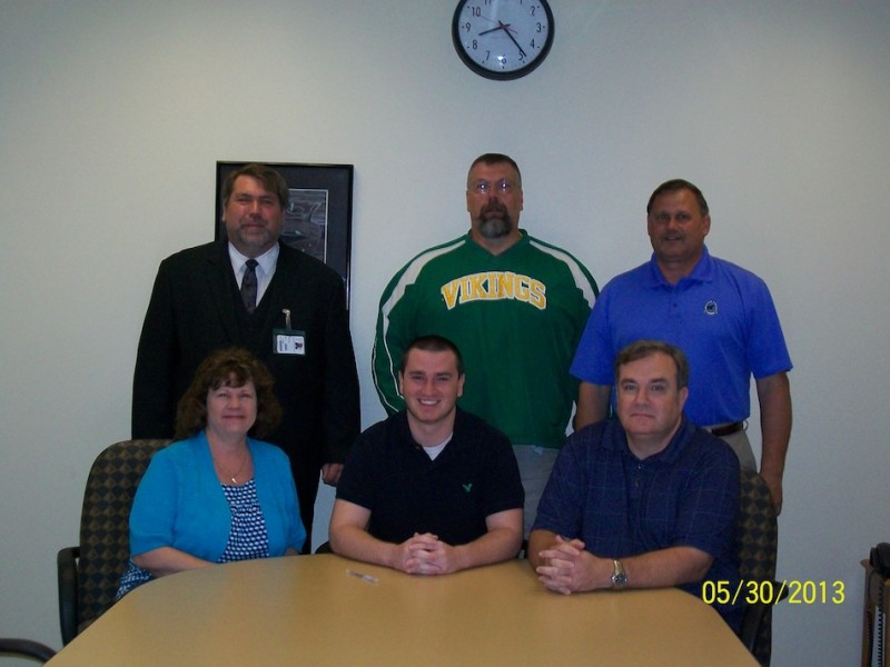 Jacob Ritchey of Tippecanoe Valley will continue his football career at Manchester University. Ritchey is pictured above in front, flanked by his parents Angie and Steve. In back are TVHS principal Kirk Doehrmann, football coach Jeff Shriver and athletic director Duane Burkhart (Photo provided)