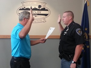 Warsaw Mayor Joe Thallemer swears in Warsaw Police Officer Ross Minear, who recently successfully completed his probationary term with the department. (Photo by Stacey Page)