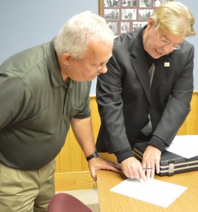 Steve Unruh prepares to sign necessary documents being shown him by Randy Girod, Kosciusko County Republican Chairman. (Photo by Deb Patterson)