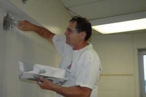 Jim Brita of the Strahm Group Inc., Fort Wayne, does drywall work in one of the C wing rooms at Wawasee High School. Eventually the walls will be painted in this room and others in the C wing as part of summer construction or renovation projects within the Wawasee Community School Corp. (Photo by Tim Ashley)