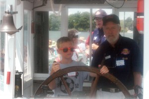 Max Degnan tries his hand at steering the Dixie during her 84th birthday cruise today. Degnan was assisted by Capt. Dave Tranter who said Degnan was already enlisted as a future captain. (Photos by Lauren Zeugner)