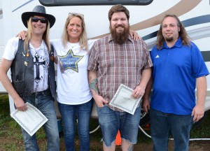 Stacey Page is pictured with the winners of the Kosciusko's Got Talent contest hosted by StaceyPageOnline.com. From left are Kevin Kyle of the Guy Franklin Band, which placed as runner up; Josh Jacoby, representing Plaxton & The Void, the grand prize winner; and Brandon Bussard is also of the Guy Franklin Band. (Photo by Alyssa Richardson)