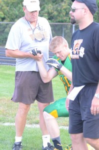 Warsaw football coach Phil Jensen helps Tanner Andrews of Tippecanoe Valley to his feet after Andrews was shaken up in Friday night's scrimmage.