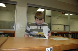 Sixth-grader Paul Lovellette looks through a book in the media center at Wawasee Middle School. Note the new windows in the background in the now fully enclosed media center. (Photo by Tim Ashley)