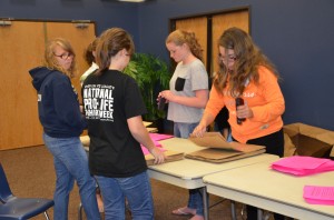 Students work to prepare the last of 4,000 paper bags that will be distributed to homes throughout the area for non-perishable food donations.