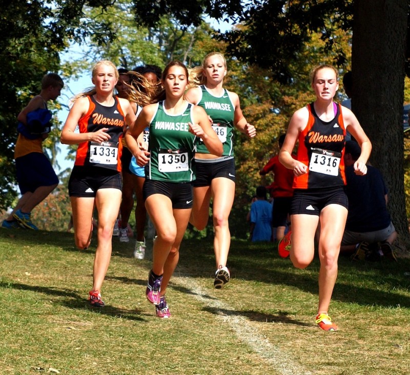 Warsaw's Brooke Rhodes (1334) and Hannah Dawson (1316) run with Bre Robinson (1350) and Courtney Linnemeier (1346) of Wawasee Saturday. Warsaw won the team championship and Wawasee placed third.