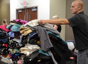 Kevin Hamtra of the local Young Adult Professionals group sorts clothing collected in a recent clothing drive to benefit Combined Community Services.