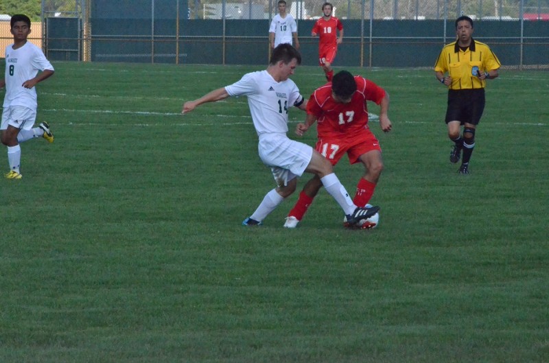 Michael Pena tries to clear a ball through the legs of Plymouth's Cesar Aguilar. Aguilar had two goals for the Pilgrims.