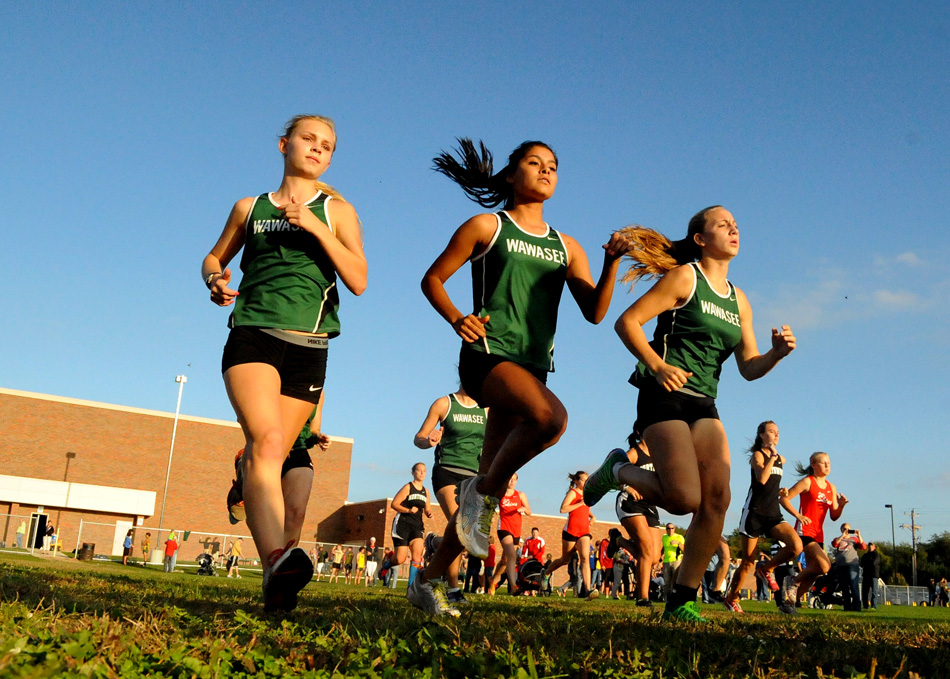 Runners from Wawasee, NorthWood and Goshen all start down the opening straightaway during the NLC triangular at Wawasee Tuesday night. (Photos by Mike Deak)
