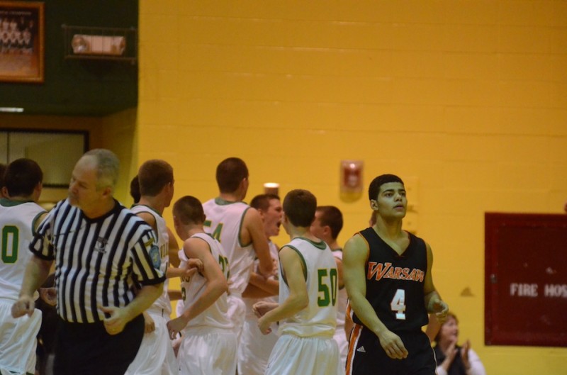 Warsaw's Darren Walcott walks off the court as Valley celebrates in the background Wednesday night.