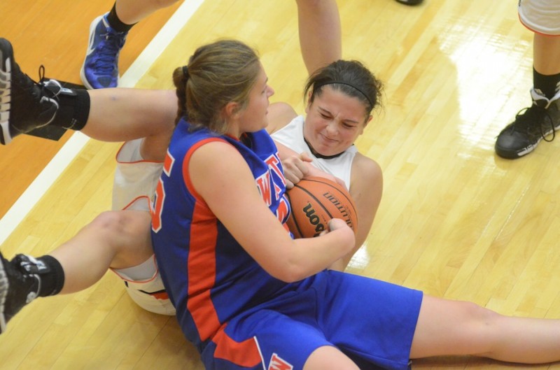 Page Desenberg of Warsaw and Whitko's Jordan Hall tussle for a loose ball Friday night. Desenberg scored eight points to help the Tigers post a 64-42 win.