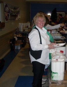 Elks member Sheri Krichbaum happily serves Thanksgiving dinner. (Photo provided)