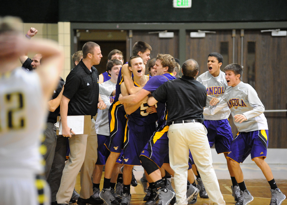 Angola's Kent Kohart, center, is mobbed by his team after hitting a game-winning basket to give the Hornets a 46-44 victory over the Wawasee Warriors Saturday night. (Photos by Mike Deak)