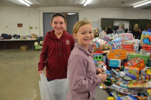 Kristin Chapman, 12, and (right) Mallory Phillips, 10, were among the volunteers to pass out new toys to families at the Toy Giveaway.  (Photo provided) 