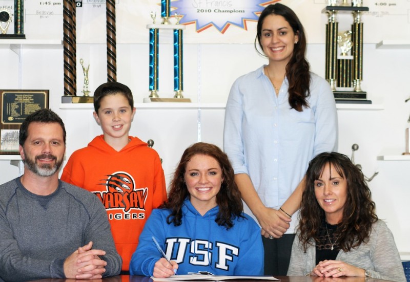 WCHS senior Emily Poe signs Wednesday to play volleyball for the University of Saint Francis in Fort Wayne. Poe is surrounded by her parents Brian and Charlotte. In back are her brother Brock and Saint Francis coach Fabiana Shields (Photo provided)