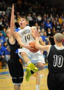 Triton's Jordan Anderson drives between NorthWood's Tanner Farmwald (10) and Kyle McCoy for a shot attempt.