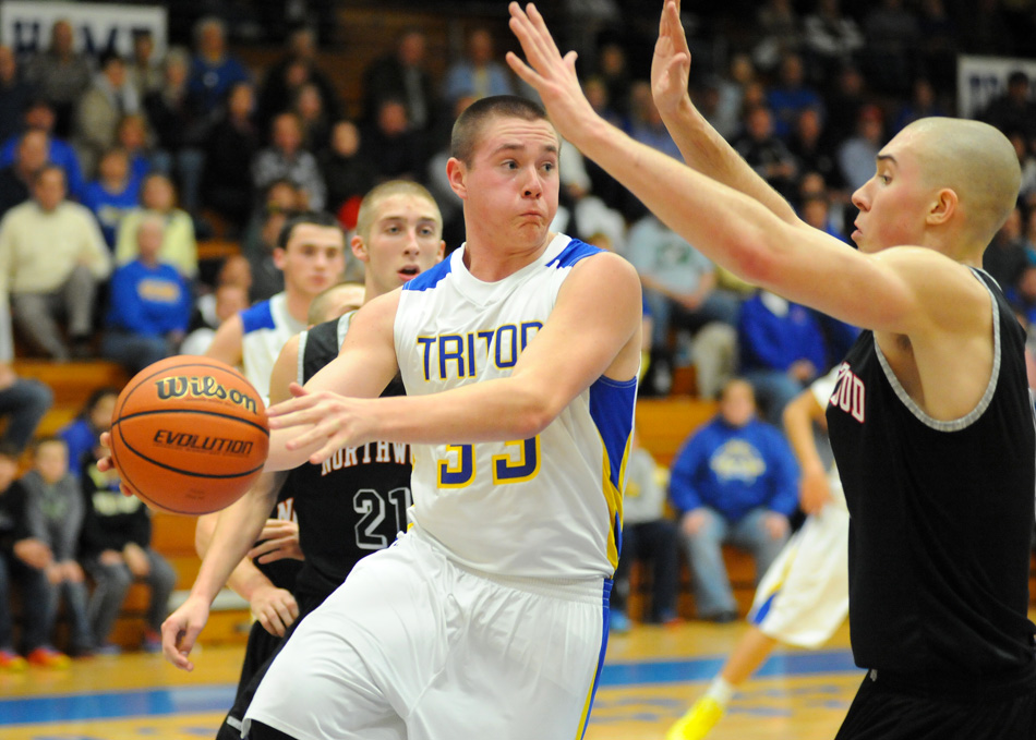 Triton's Skyler Reichert zips a pass around NorthWood's Zach Zurcher Friday night. Zurcher and the Panthers were too much for Triton, 59-40, at the Trojan Trench. (Photos by Mike Deak)