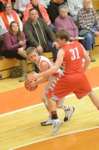 Nate Pearl of Warsaw looks around the defense of Alex Hartsough of Goshen Friday night.