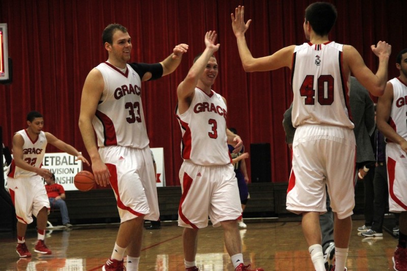Grace College players Greg Miller, Logan Irwin and Kyle Fillman celebrate Saturday. The Lancers rallied to top Taylor for their fifth straight win (Photo provided by Grace College Sports Information Department)