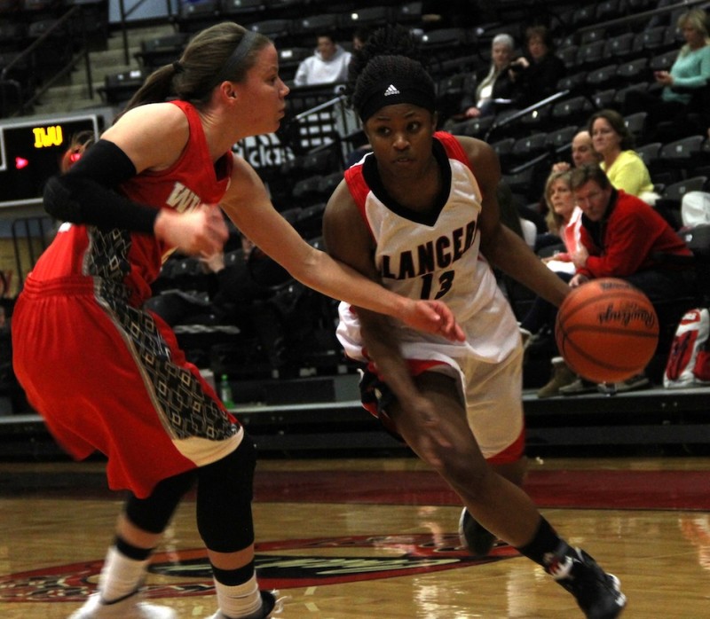 Grace College senior guard Juaneice Jackson drives around Taylor Goshert of Indiana Wesleyan Wednesday night. Jackson scored 23 points as the Lancers upset the No. 4 Wildcats 69-67 in Winona Lake (Photo provided by Grace College Sports Information Department)